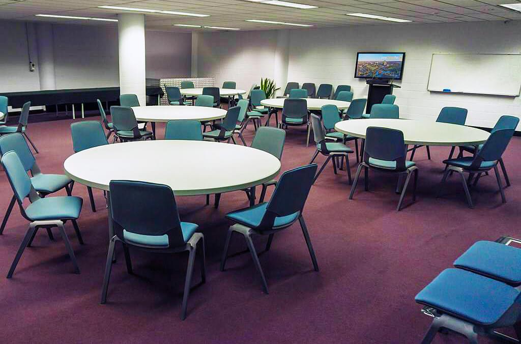 Madison de Rozario conference room with table and chairs, TV and whiteboard at the front of the room.